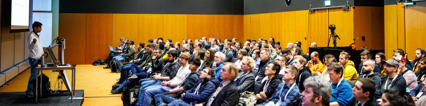 Medya speaking on stage at a developer conference